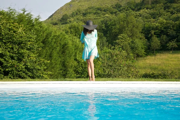 Μπλε φόρεμα γυναίκα στα σύνορα πισίνα — Φωτογραφία Αρχείου