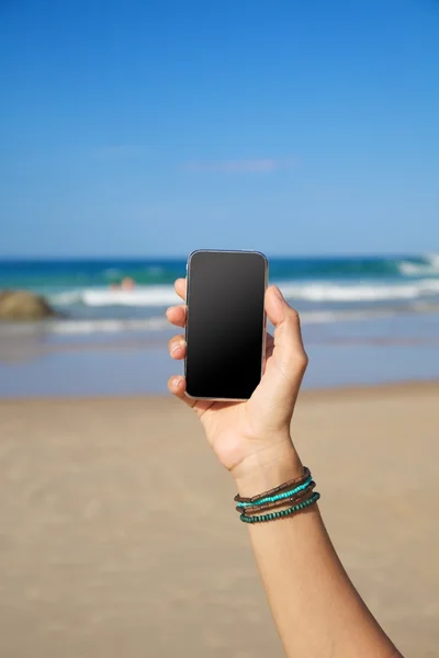 ビーチで空白の携帯電話 ストック画像