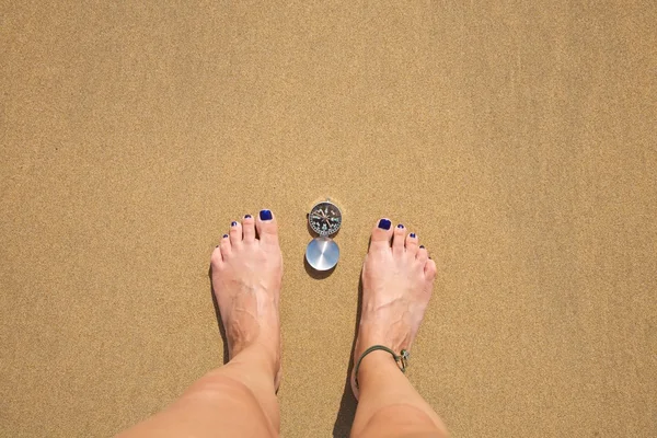 Kompas tussen vrouw voeten — Stockfoto