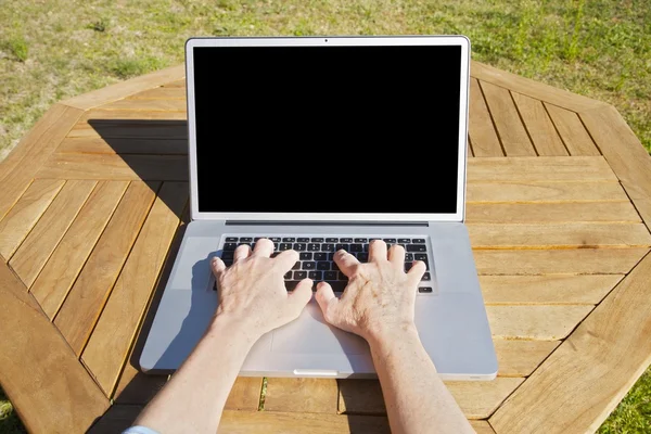 Mujer vieja escribiendo en el ordenador portátil —  Fotos de Stock