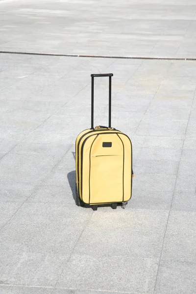 Yellow suitcase alone — Stockfoto