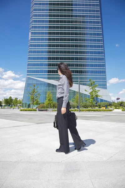 高層ビルの横を歩いて女性実業家 — ストック写真