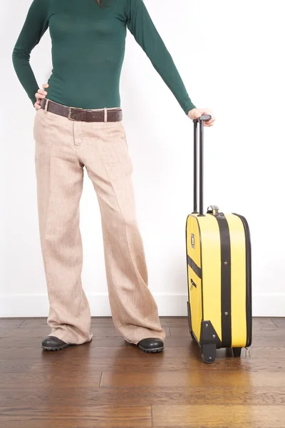 Ожидание с желтым чемоданом — стоковое фото