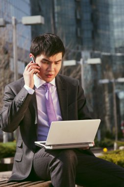 Young businessman talking on mobile phone. clipart