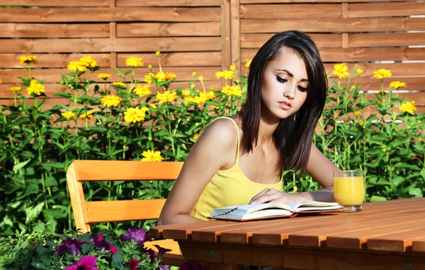 Menina bonita com livro no jardim — Fotografia de Stock