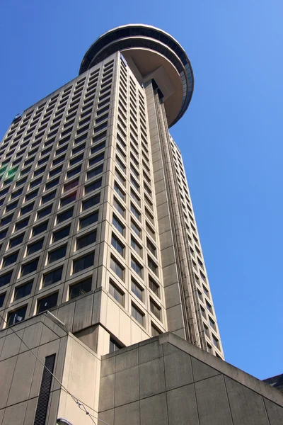 Hoog stijgingsgebouw met een toren draairestaurant. — Stockfoto