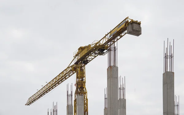 Torn kran, cement pelare och smidesjärn från en byggarbetsplats — Stockfoto