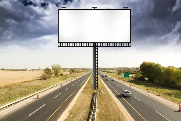Рекламний щит з бурхливому небі на американський шлагбаума на шлях — стокове фото