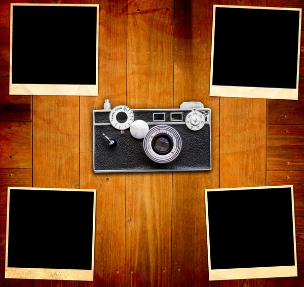Vintage obrázky a fotoaparát na starý dřevěný stůl — Stock fotografie