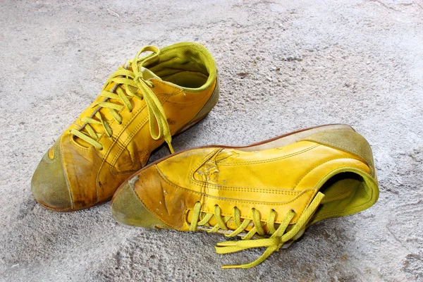 stock image Old yellow shoes on concrete