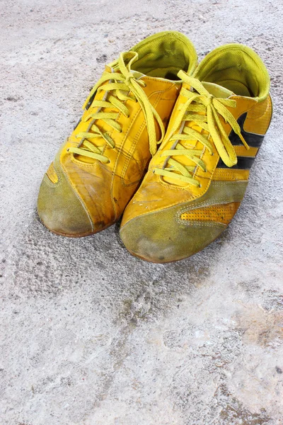 stock image Old yellow shoes on concrete