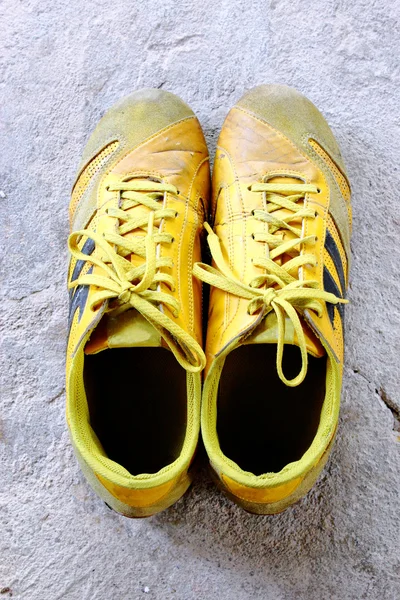 在混凝土上的旧黄色鞋 — 图库照片