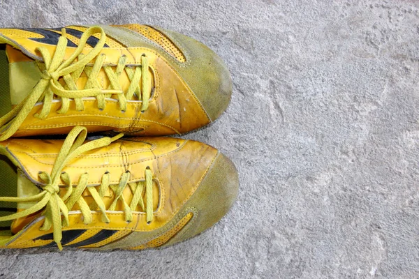 Gamla gula skor på betong — Stockfoto