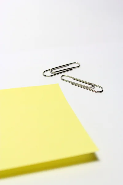 Yellow note with clip on white background — Stock Photo, Image