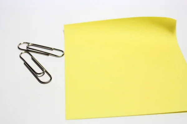 Nota gialla con clip su sfondo bianco — Foto Stock