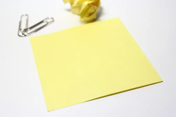 Жовта нота з затискачем на білому тлі — стокове фото
