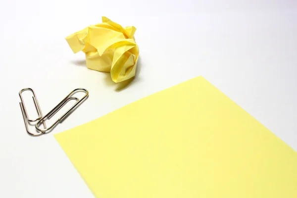 Nota amarela com clipe no fundo branco — Fotografia de Stock