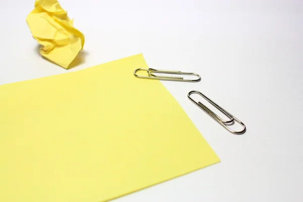 Nota amarilla con clip sobre fondo blanco —  Fotos de Stock
