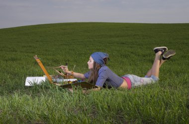 Girl painting on the meadow clipart