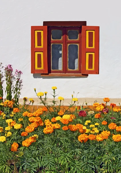 Blomsterrabatt under vintage fönster — Stockfoto