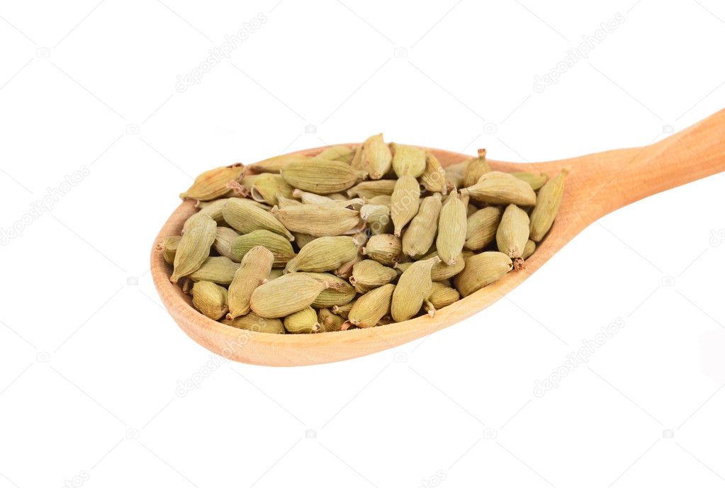 Cardamom pods in wooden spoon