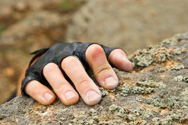 Rockclimber's hand on granite rock in gloves — Stock Photo, Image