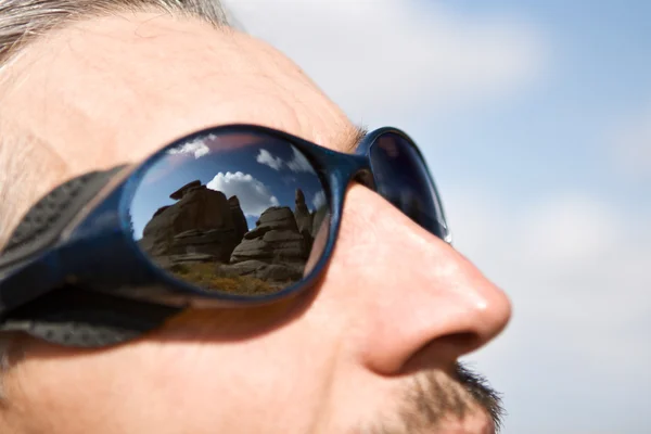 De ernstige man in berg punten met weerspiegeling van prachtige — Stockfoto