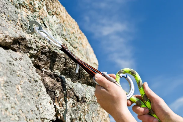 Спортсмен вешает карабин и веревку в скале — стоковое фото