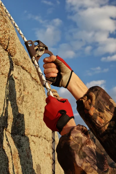 Hands of climber I work with equipment on rock. — Stock Photo, Image