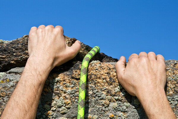 Rockclimber's hands and rope