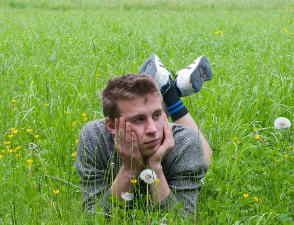 Een jonge man liggen in de weide — Stockfoto
