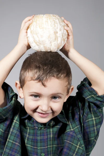 Pequeño niño sosteniendo pomelo — Foto de Stock