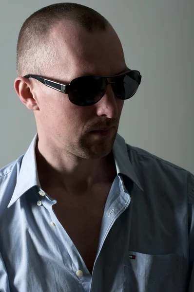 Ernster junger Mann mit Sonnenbrille im Studio — Stockfoto