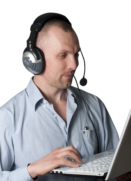 stock image A young man with headphones and a laptop