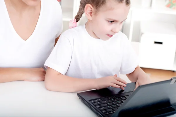 Moeder en dochter zijn werken samen voor een laptop — Stockfoto