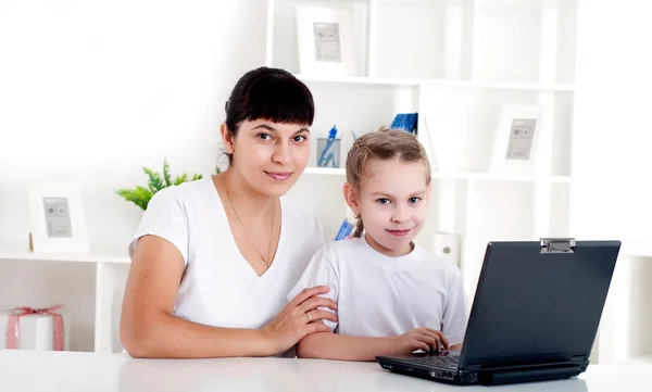 Moeder en dochter zijn werken samen voor een laptop — Stockfoto