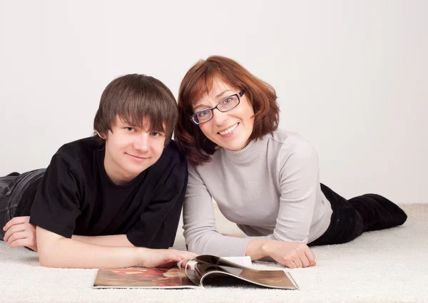Mor och son är tillsammans, läsa tidningen — Stockfoto