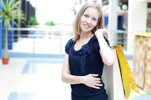 Молодая женщина в торговом центре покупает одежду — стоковое фото