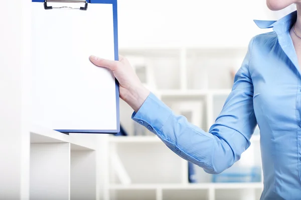 Stock image Woman puts a tablet with documents in a Shelfs