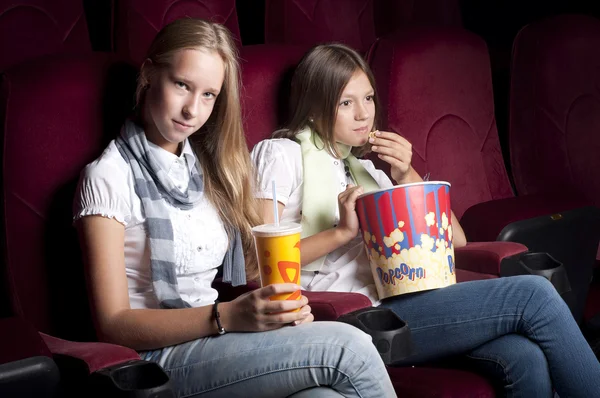 Two beautiful girls watching a movie at the cinema — Stock Photo, Image