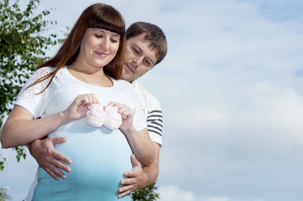 Mężczyzna i kobieta w ciąży, przytulanie w parku — Zdjęcie stockowe