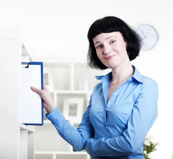 Woman puts a tablet with documents in a Shelfs — Stock Photo, Image
