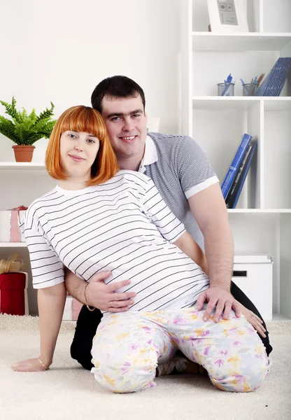 Portrét muže a těhotnou manželku doma s — Stock fotografie
