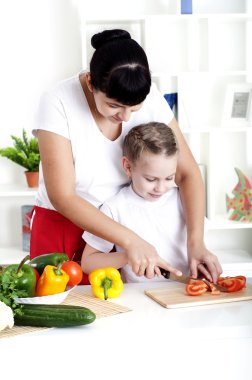 Anne ve kızı birlikte yemek pişiriyor.