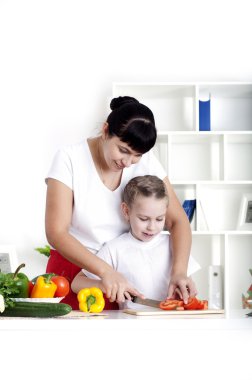 Anne ve kızı birlikte yemek pişiriyor.
