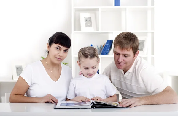 Família lendo um livro juntos — Fotografia de Stock