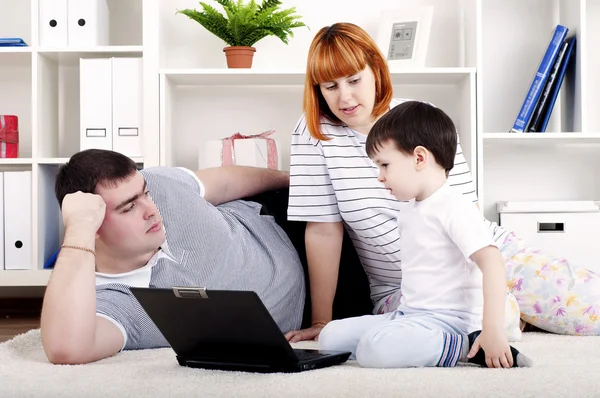 Familie op zoek naar een laptop — Stockfoto