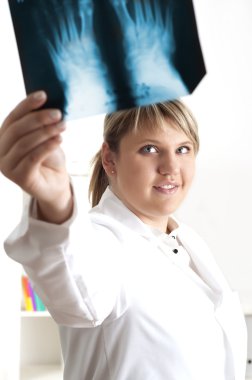 Female medic looking at x-rays clipart