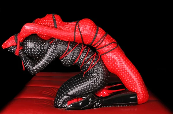 Rojo y negro fetiche modelos atados con cuerda — Foto de Stock