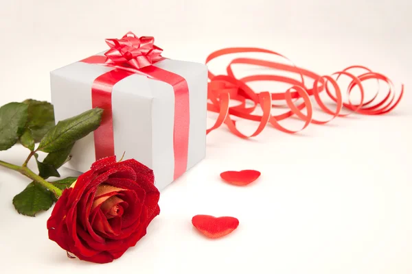 Червона троянда, два серця і білий подарунок на білому тлі — стокове фото